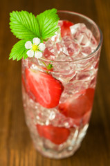 refreshing drink with a strawberry and ice close-up