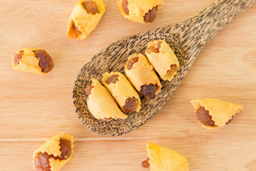 Pineapple pie on a wooden spoon on the table.