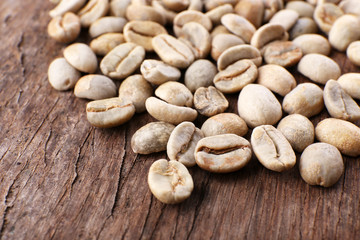 Heap of green coffee beans on table close up