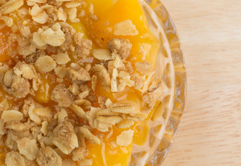 Bowl of peaches with brown sugar and oats on wood table