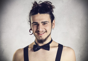 Handsome shirtless young man wearing braces and a bow tie