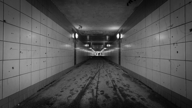 Pedestrian tunnel. An urban pedestrian underpass with graffiti and low lighting making it an intimidating location.