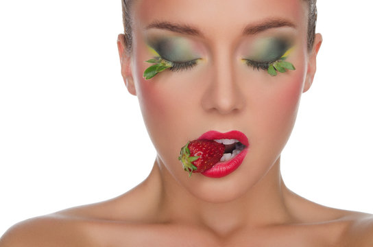 beautiful woman with strawberry in mouth