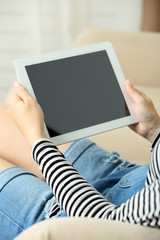 Female hand holding PC tablet on home interior background