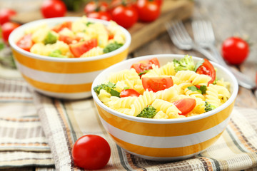 Delicious pasta in bowl on grey wooden background