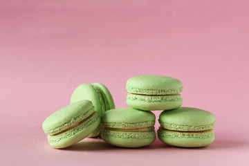 Green macarons on pink paper background