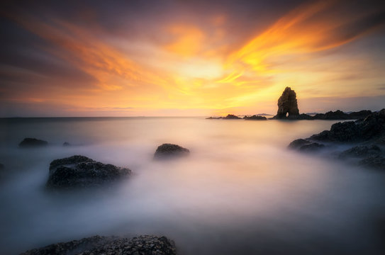 Sea wave hit the rock at sunset in Thailand