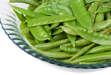 Snow Peas in a Bowl – Steamed snow peas in a glass bowl. White background.