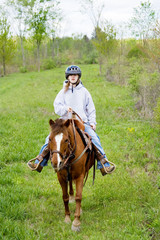 Young Horseback Rider &ndash; A young girl rides a horse in the country.
