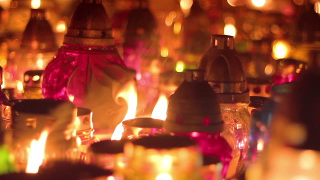 Close shot of many candles in graveyard mass mourning