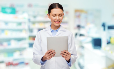 smiling female doctor with tablet pc at drugstore
