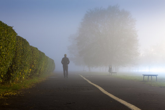 Man at urbanized path during misty weather