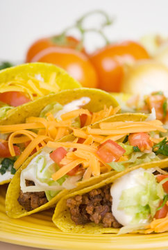 Beef Tacos Plate – Ground beef tacos on a plate, with lettuce, sour cream, cheese, and tomatoes.