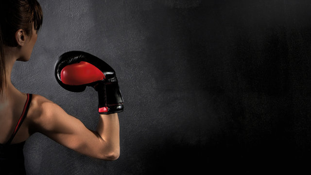  Woman Boxer Biceps with Red Boxing Glove on Black Background, high contrast with saturated grunge filter