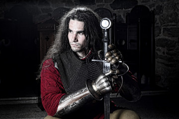 Fototapeta na wymiar Half Length Portrait of Knight With Sword Looking Away