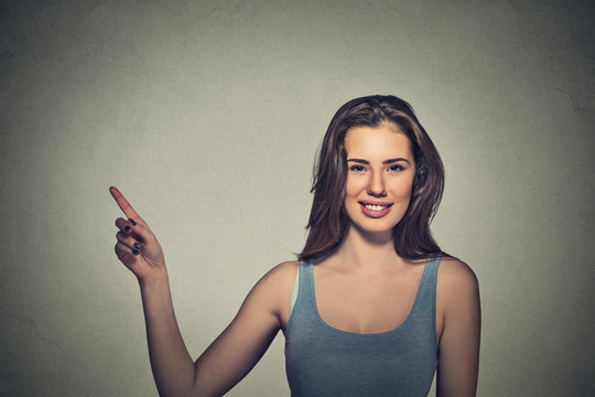 woman pointing with finger up to side at empty copy space