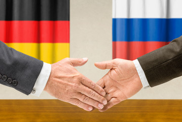 Vertreter Deutschlands und Russlands reichen sich die Hand