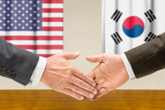 Vertreter der USA und Südkoreas reichen sich die Hand