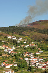 Fototapeta na wymiar Incendie (feu de bruyères) au dessus du village de Campanho au portugal (région de Villareal - Porto).
