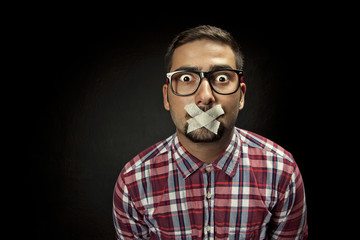 Young man with taped mouth - obrazy, fototapety, plakaty