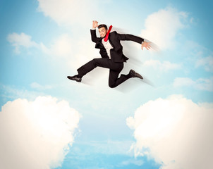 Fototapeta na wymiar Business person jumping over clouds in the sky