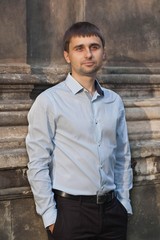 Portrait of a young man near the wall.