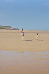 maman courant sur la plage avec sa fille