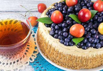 Celebratory cake with blueberries, sweet cherry, mint leaves and