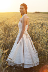 Beautiful bride standing in the field of rye