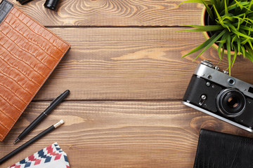 Office desk table with camera, supplies and flower