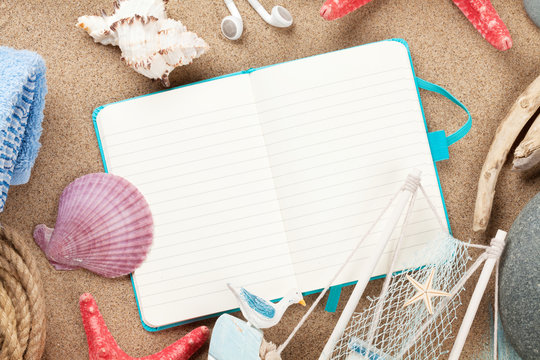 Travel and vacation notepad with items over sand