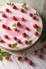 Pink raspberry cheese cake with fresh berries close-up. vertical top view

