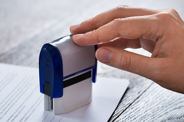 Person Hands With Stamper And Document