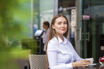 Happy Business woman in white shirt drinking a cup of coffee in