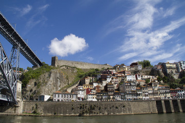 Fototapeta na wymiar Ponte de Dom Luis ! and old city walls viewed from the Douro Diver.Oporto,Portugal