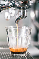 Espresso running in glass on professional coffee maker