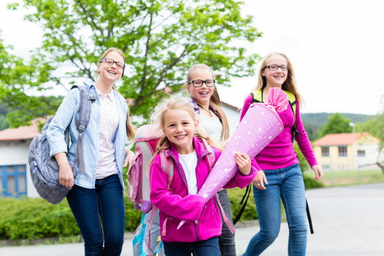 Gruppe Sch&uuml;ler auf dem Schulhof l&auml;uft in die Schule