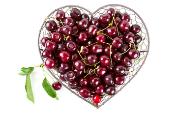 cherries in a heart-shaped metallic basket isolated on white