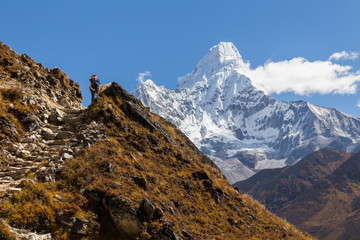 Woman backpacker standing in front Ama Dablam mountains.