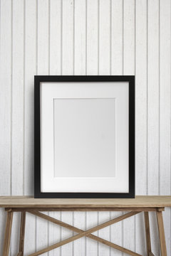 Black picture frame on wood table