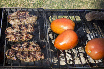 This is a photograph of Kabobs and Tomatoes on a charcoal grill