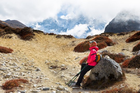 Woman tourist backpacker resting rock Ama Dablam mountain trail.