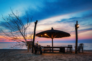Wooden chairs and umbrella on sand beach