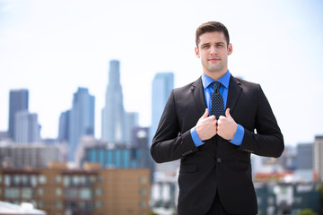 Confident businessman in a suit standing tall and proud attorney buildings in background