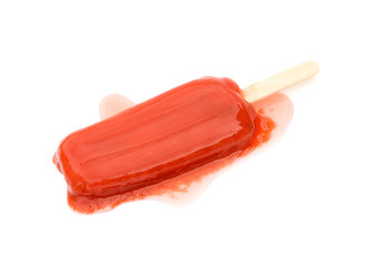 red popsicle melting on a white background