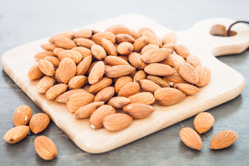 Almond nuts on wooden plate