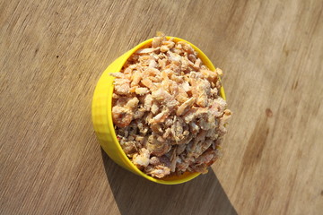 dried shrimp in yellow bowl isolated on wood background
