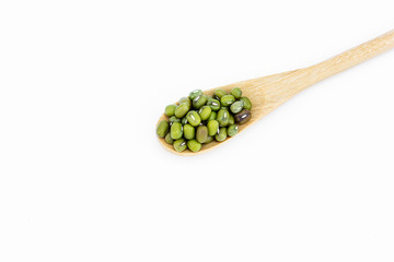 mung beans in wooden spoon over white background