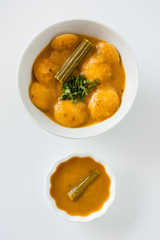 Indian sambar mini idly - A traditional ethnic south Indian breakfast of Sambar Idly (Idli / rice cake) with mini idly in a bowl of sambar with drumstick and cilantro as garnish. Natural light used.