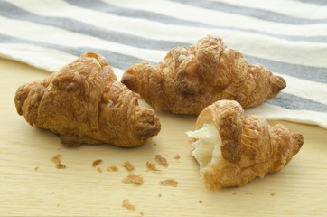 Three croissant on wood board